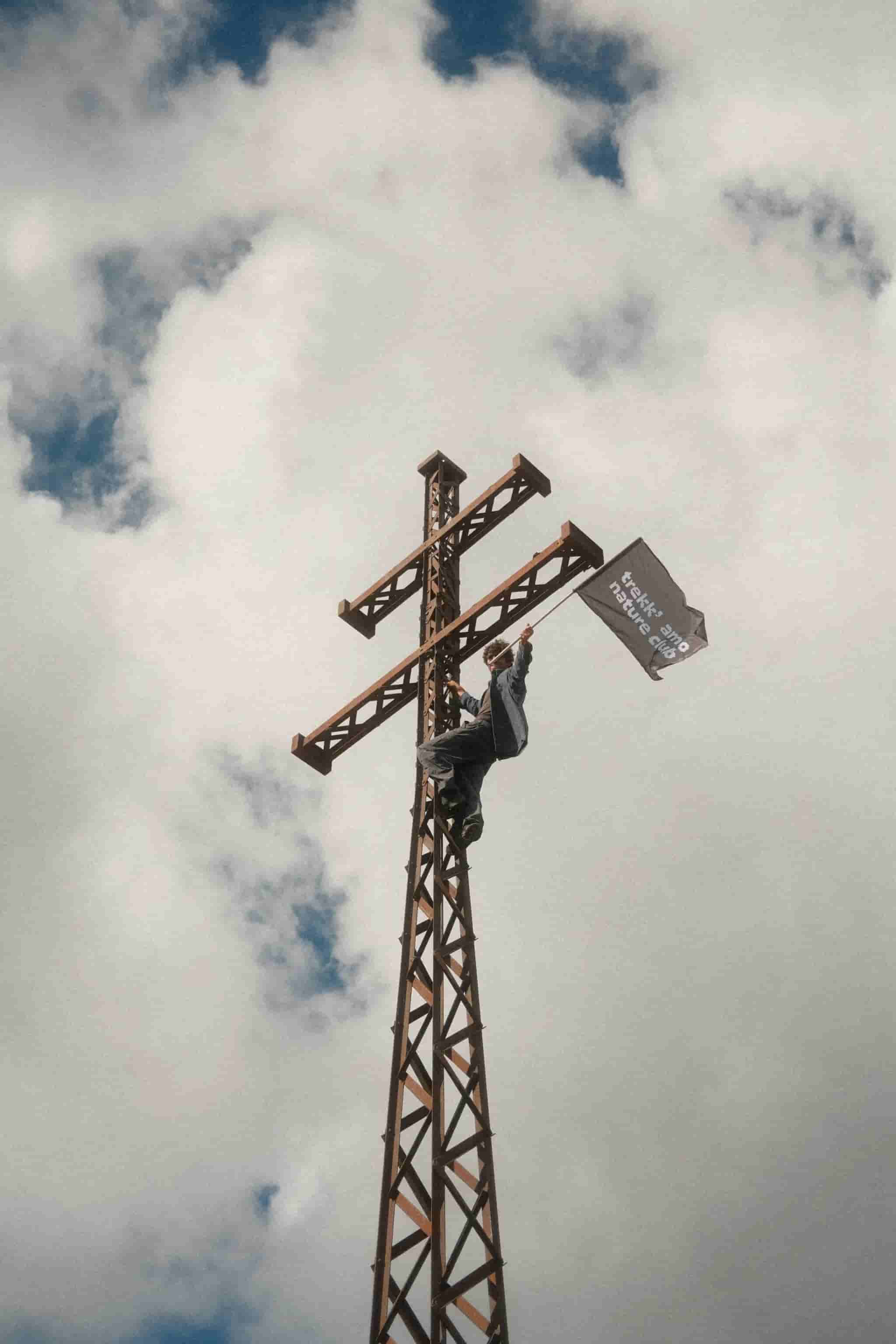 Giorgio con la bandiera arrampicato sulla croce
